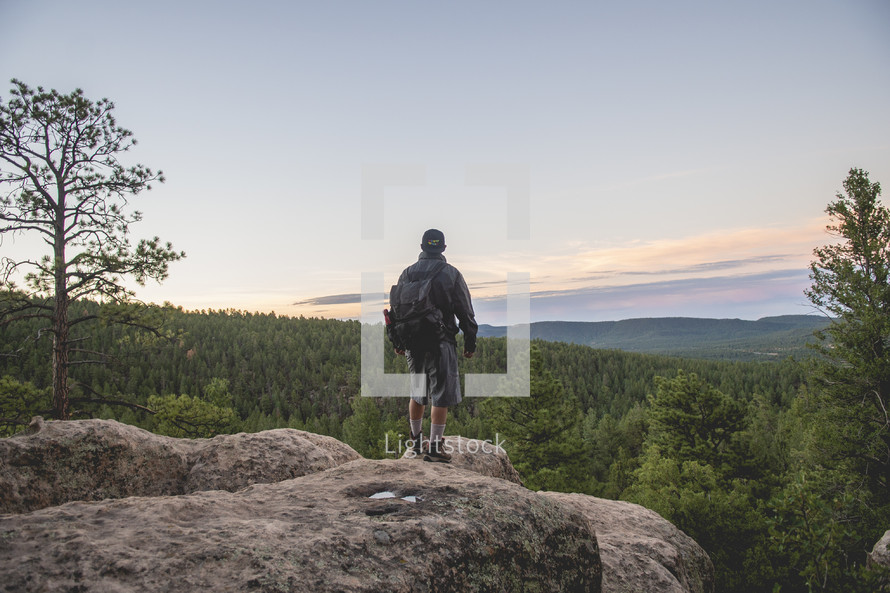 a man standing on a mountaintop at sunrise 
