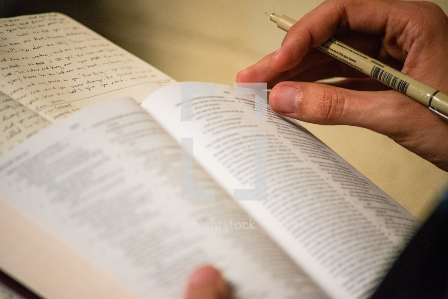 person reading a Bible and taking notes 
