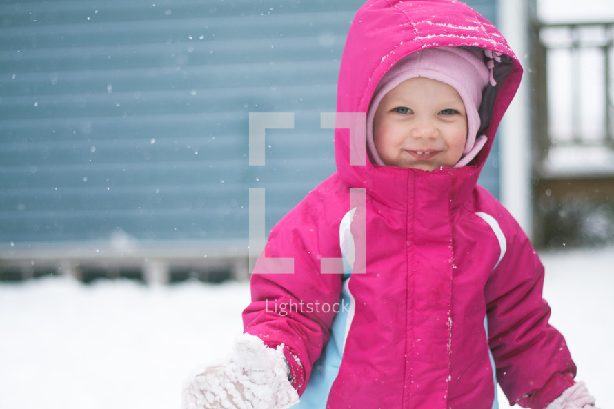 a toddler girl playing in the snow 