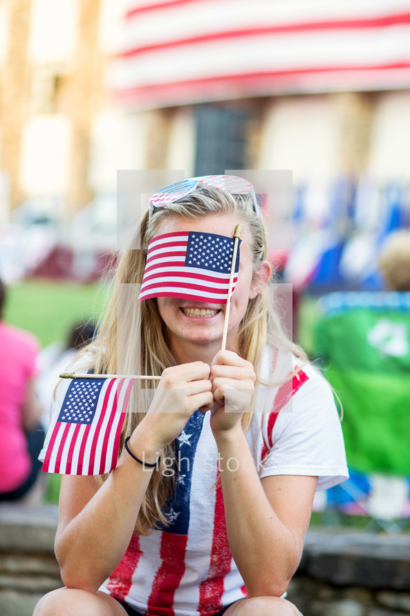 woman holding an American flag at a parade 