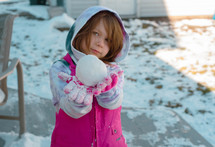 child holding a snow ball 