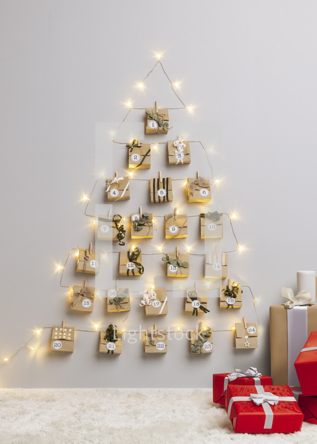 24 Gifts Calendar Hanging on Wall with Twinkling Christmas Lights and gifts on the floor