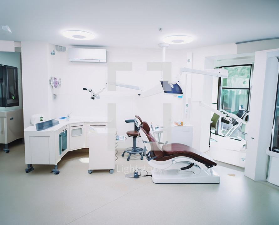 Modern dental office. Brown leather chair and other accessories used by dentists in white medic light