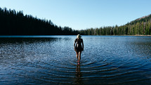 a woman walking through a pond 