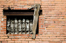 bared window on a brick wall 