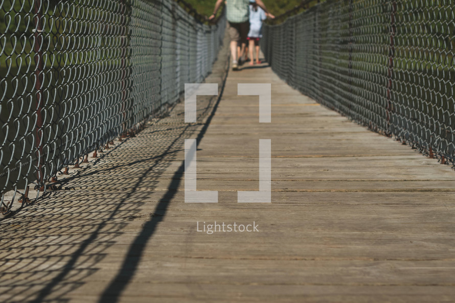 people crossing a footbridge 