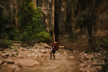 woman hiking through a stream 