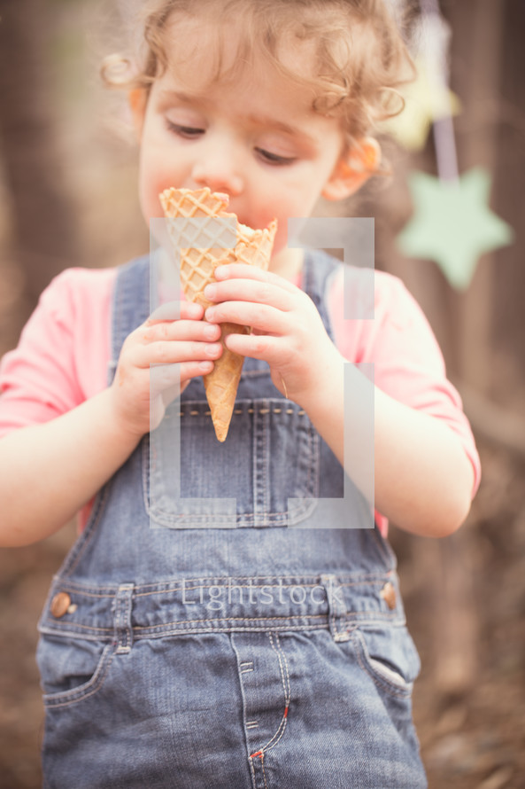 toddler girl eating an ice cream cone 