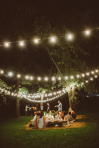 friends sitting on the ground for an outdoor dinner party 