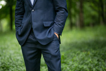 A man in a blue suit standing outdoors.