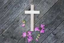 pink flowers and cross on a rustic wood background 