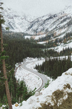 a curvy road and snow covered mountain 