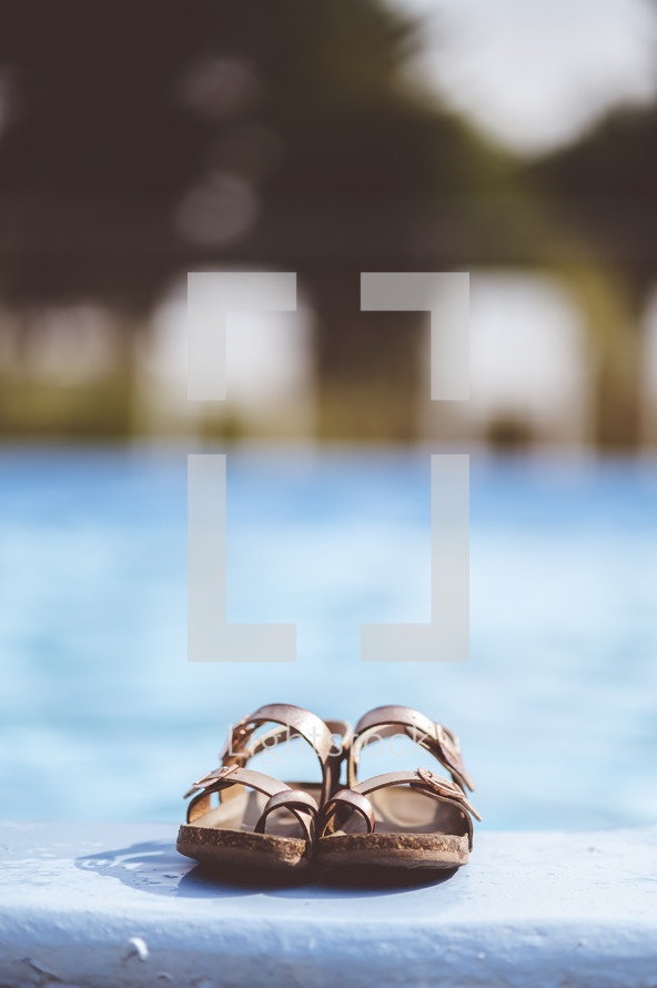 sandals by the side of a pool 