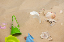 toys and shells in the sand 