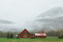 log cabin and foggy mountain in background 