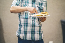 a man standing holding a plate of food 