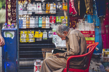 Vendor reading a book at an outdoor market in Egypt 