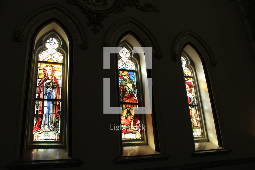 A set of three Stained glass windows in a historic church sanctuary that is over 200 years old in a historic city in the southeastern United States. 