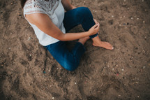 a woman sitting in sand 