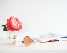 headphones, flower, vase, journal, and reading glasses 
