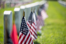 American flags at grave markers at a Veteran's Cemetery 