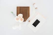 cellphone, wood tray, stationary, roses, and spool of ribbon