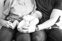 new parents holding their newborn baby 