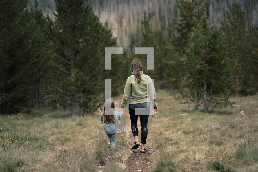 mother and daughter walking on a trail 