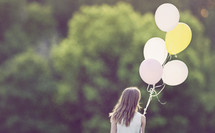 a girl walking with balloons 