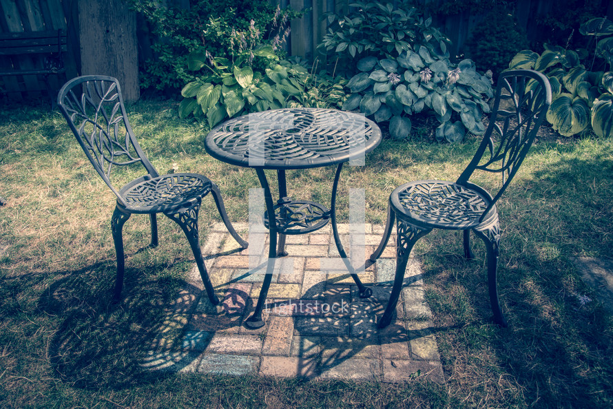 iron table and chairs on a patio outdoors 
