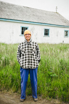 man bundled up in hoodie and cap standing outdoors in Alaska 