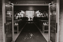 Black and white of wedding with confetti in the aisle 