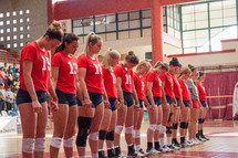 praying volleyball team holding hands 