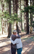 a couple hugging in the woods 