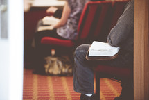 Bibles in the laps of people in a congregation 