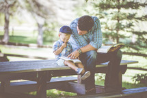 father and son reading a Bible together 