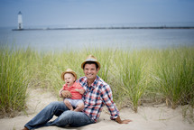 portrait of a father and baby in the sand on a beach 