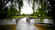 walking bridge over a pond in a park