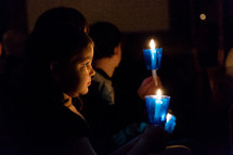 a child at a Christmas Eve candlelight service 