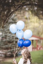 woman holding blue balloons 