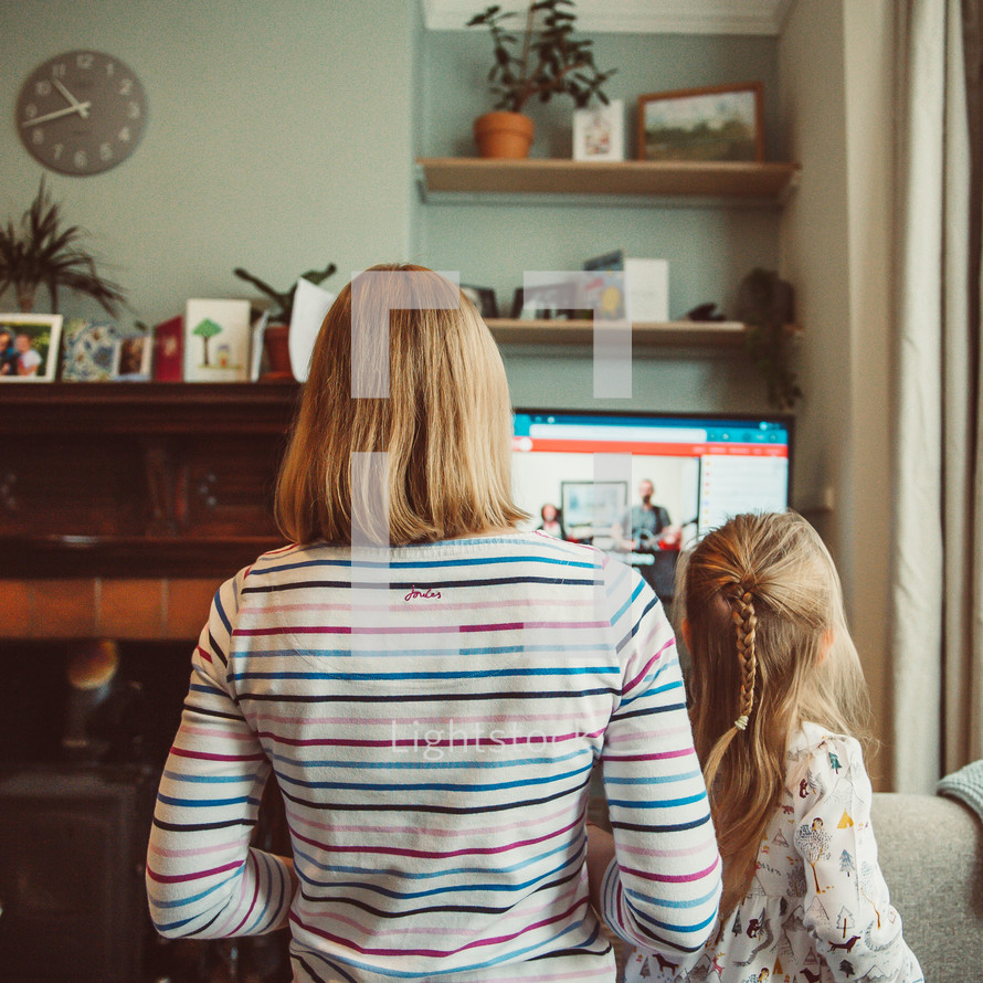 mother and daughter watching an online worship service 