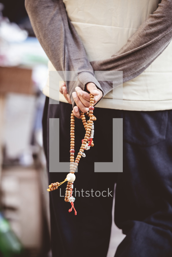 man holding prayer beads in Tibet 
