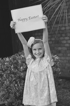 A little girl holding a Happy Easter sign in black and white 
