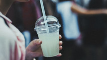 person holding a cup with straw 