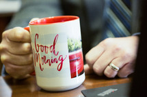 Businessman starting his day with a coffee mug that says "Good Morning".