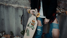 a teen girl holding a skateboard 