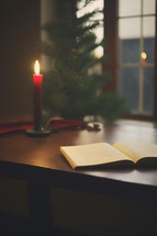 Serene Christmas Setting with Open Bible and Candle