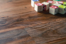 alphabet wooden blocks on a wood floor 
