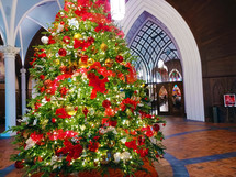 Christmas trees with red bows in a church