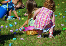 Kids gather Easter Eggs in their Easter baskets at an outdoor Easter Egg hunt at a local church outdoor event. 